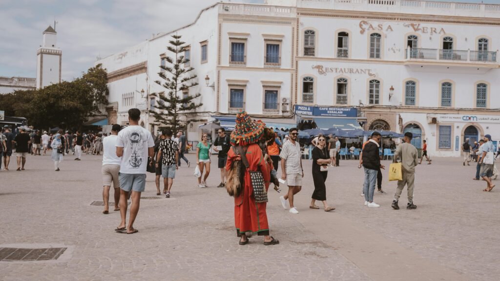 Vibrant street life in Essaouira's historic square, showcasing Moroccan culture and architecture.
